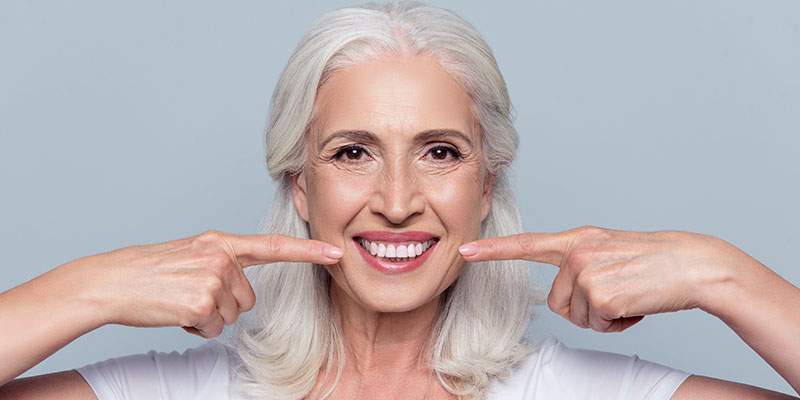 Lady pointing at her smile